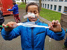 Ein Junge spielt mit Seifenblasen.