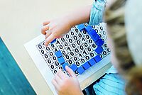 Auf dem Bild sieht man ein Mädchen, dass mit einer Informatik-Tafel spielt
