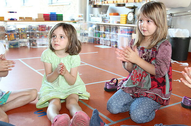 Kinder klatschen in die Hände und zählen dabei die einzelnen Klatscher.