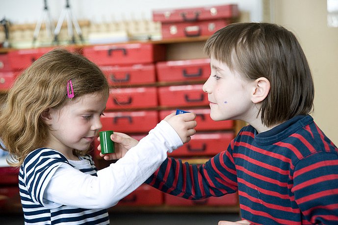 Zwei Kinder halten sich gegenseitig Filmdosen zum Riechen unter die Nase