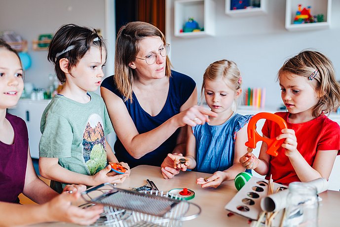 four children and a teacher explore magnets