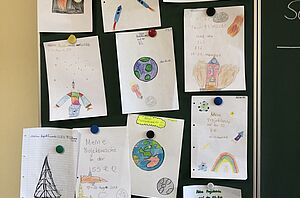Auf dem Bild sieht man viele gemalte Bilder der Kinder, die unterschiedliche Raketen zeigen
