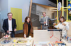 Zwei Frauen und zwei Männer stehen in einem Mitmach-Museum an einer Strom-Experimentierstation.