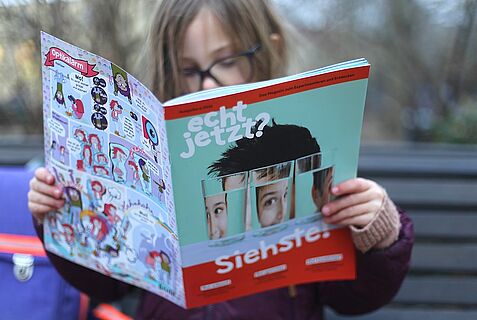 Ein Mädchen liest in der neuen Ausgabe der "echt jetzt?" zum Thema "Siehste!".