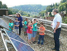 Mädchen und Jungen aus der Kita betrachten eine Photovoltaikanlage.