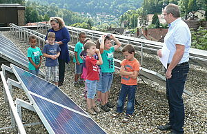 Auf dem Dach des lokalen Energieversorgers betrachten die Kinder eine Photovoltaikanlage.