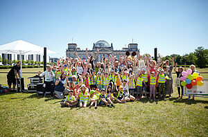 Gruppenfoto mit vielen Kindern auf der Wiese vorm Reichstag