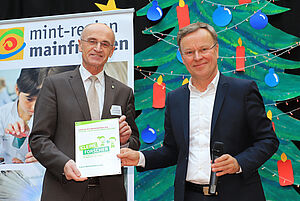 Michael Fritz übergibt die Netzwerkplakette an Landrat Wilhelm Schneider.