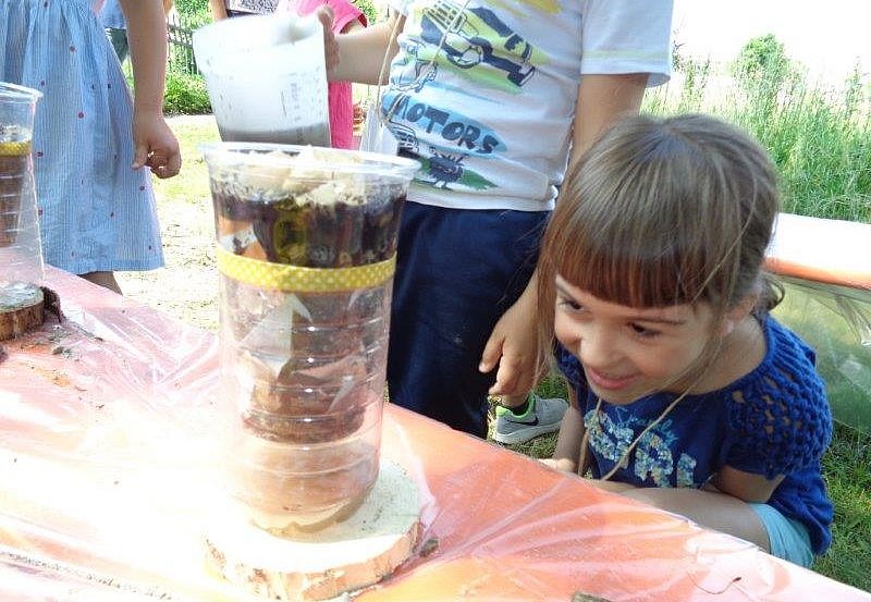 Ein Kind schaut sich ein Wasserfiltersystema us Flaschen an